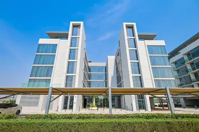 a large white building with a car parked in front of it at 1BR Close to Crystal Lagoon in District One Meydan in Dubai