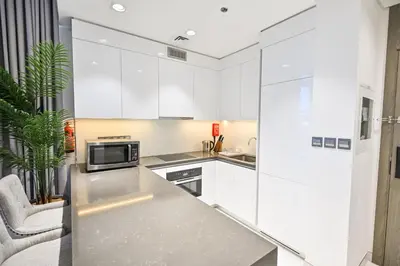 a kitchen with white cabinets and a counter top at Direct Access to Crystal Lagoon 1br unit in District One Meydan in Dubai