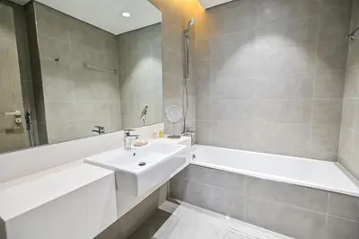 a white bathroom with a sink and a tub and a sink at Amazing 1 Bedroom in District One Meydan in Dubai