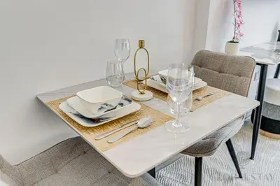 a white table with plates and glasses on it at GLOBALSTAY Azizi Riviera 45 in Dubai