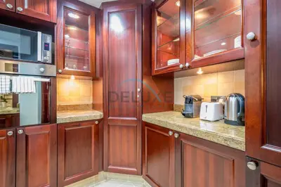 a kitchen with wooden cabinets and a microwave at Appealing 1BR Apartment at Miska 2 Old Town, Downtown Dubai by Deluxe Holiday Homes in Dubai