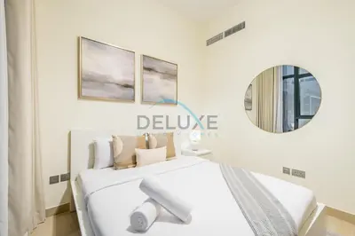 a white bedroom with a bed and a mirror at Relaxing 1BR Apartment with Built-in Wardrobe & Community View in Azizi Riviera 4, Al Merkadh by Deluxe Holiday Homes in Dubai