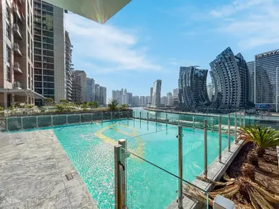 a large swimming pool in a city with tall buildings at Stylish Home with Direct Pool Access by the Canal in Dubai