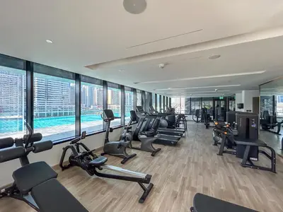 a gym with a bunch of treadmills and ellipticals at Stylish Home with Direct Pool Access by the Canal in Dubai
