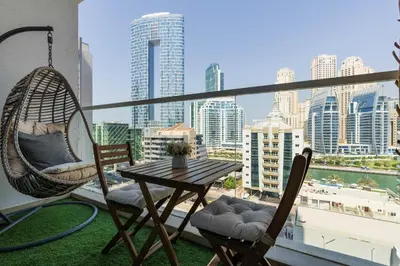 a balcony with a table and chairs and a view of the city at Beautiful Stylish Apartment with Marina Views in Dubai