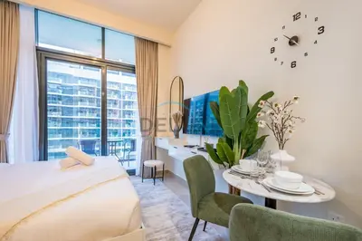 a bedroom with a bed and a table and a desk at Lovely Studio Apartment at Azizi Riviera 46 in Al Merkadh by Deluxe Holiday Homes in Dubai