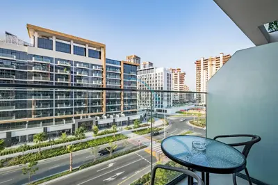 a balcony with a table and a view of a city at Lovely Studio Apartment at Azizi Riviera 46 in Al Merkadh by Deluxe Holiday Homes in Dubai