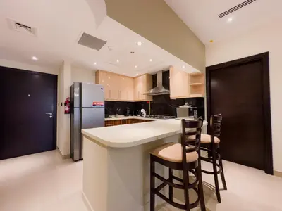 a kitchen with a refrigerator and two bar stools at Prime 2BR with Burj Khalifa & Dubai Canal View - 20AB16 in Dubai