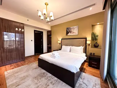 a bedroom with a large bed and a chandelier at Prime 2BR with Burj Khalifa & Dubai Canal View - 20AB16 in Dubai