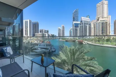 a balcony with chairs and a view of a river at AirDXB - Exceptional 3bedroom with the incredible view in Dubai Marina in Dubai