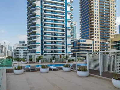a balcony with chairs and a large building at AirDXB - Exceptional 3bedroom with the incredible view in Dubai Marina in Dubai