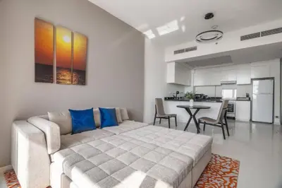 a bedroom with a large bed and a kitchen at Exquisite 1Bedroom With City Views in Dubai
