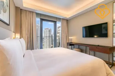 a hotel room with a bed and a desk with a television at Keysplease Address Opera 2BR Downtown 26 in Dubai