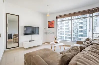 a living room with a couch and a tv at Elegant 2BR in Park Island Bonaire, Dubai Marina by Deluxe Holiday Homes in Dubai