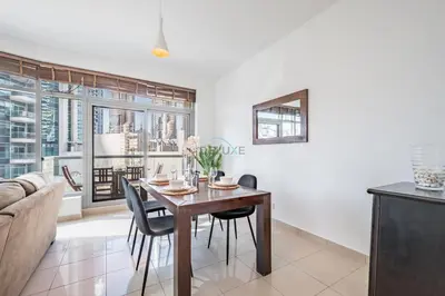 a dining room with a table and chairs and a couch at Elegant 2BR in Park Island Bonaire, Dubai Marina by Deluxe Holiday Homes in Dubai