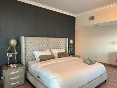 a bedroom with a large white bed and a wall at Lovely 3BHK with private beach in Dubai