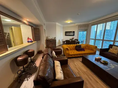 a living room with a brown leather couch and chairs at Lovely 3BHK with private beach in Dubai