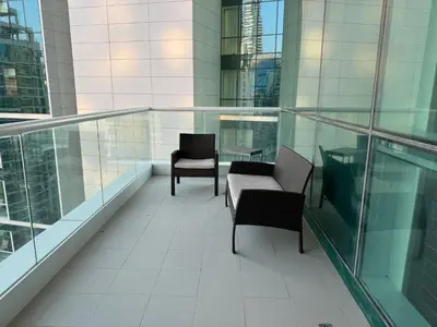 a balcony with two chairs and a table on a building at Lovely 3BHK with private beach in Dubai