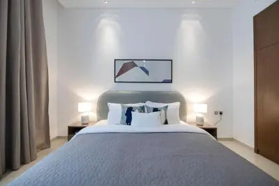 a bedroom with a large bed with two lamps at 2BR API 1000 Community View Jumeirah in Dubai