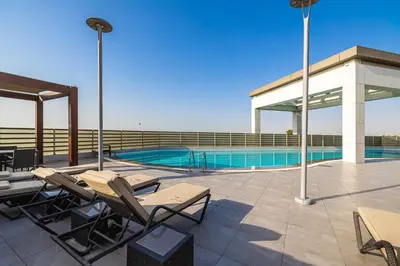 a patio with chairs and a swimming pool at 2BR API 1000 Community View Jumeirah in Dubai