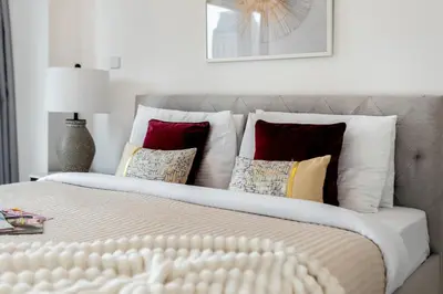 a bedroom with a large bed with many pillows at The Smart Concierge - Damac Heights in Dubai