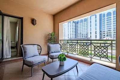 a room with two chairs and a table and a balcony at Apartment with Palm Jumeirah view I Golden Mile in Dubai