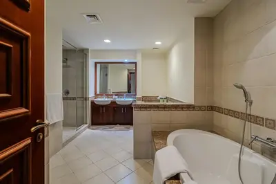 a large bathroom with two sinks and a tub at Apartment with Palm Jumeirah view I Golden Mile in Dubai