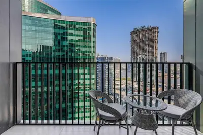a balcony with chairs and tables on a building at Knokey Ahad Residence in Dubai