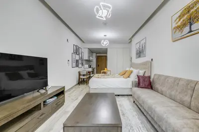 a living room with a couch and a bed at Knokey Ahad Residence in Dubai