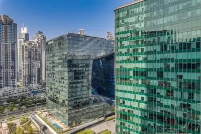 a tall glass building in a large city at Knokey Ahad Residence in Dubai