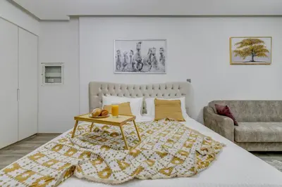 a bedroom with a bed with a table and a couch at Knokey Ahad Residence in Dubai