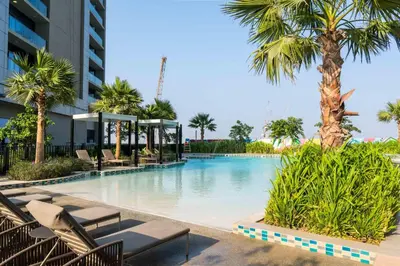 a swimming pool at a hotel with chairs and palm trees at Knokey Aykon City in Dubai