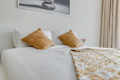 a white bed with two pillows on top of it at Knokey Bay Square in Dubai
