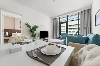 a living room with a table with glasses and a couch at Chic Living 1 BHK with Beach Access in Dubai