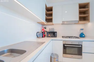 a white kitchen with a sink and a microwave at Downtown Views Tower 2 brand new apt in Dubai
