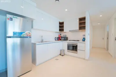a kitchen with white cabinets and a refrigerator at Downtown Views Tower 2 brand new apt in Dubai