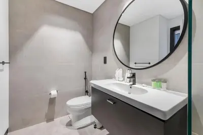 a bathroom with a sink and a mirror and a toilet at Waves - Fully Equipped Studio for a Perfect Stay in Dubai in Dubai