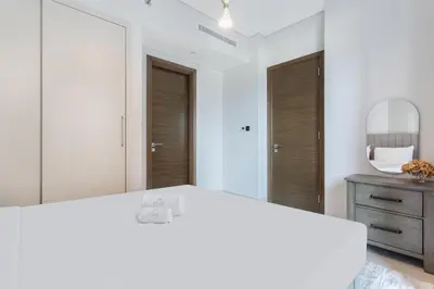 a bedroom with a white bed and a mirror at STAY BY LATINEM Luxury 2BR Holiday Home CV A813 near Burj Khalifa in Dubai