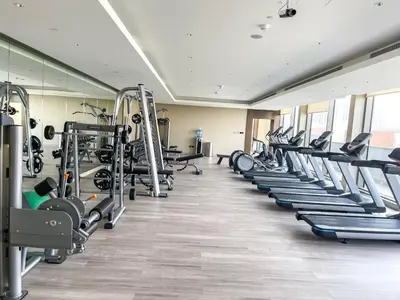 a gym with rows of treadmills and machines at STAY BY LATINEM Luxury 2BR Holiday Home CV A813 near Burj Khalifa in Dubai