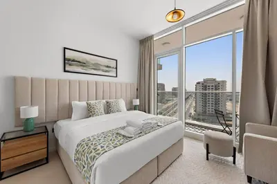 a bedroom with a large bed and a large window at Unique 1 BHK Near To Metro in Dubai