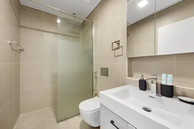 a bathroom with a toilet and a sink and a shower at Unique 1 BHK Near To Metro in Dubai