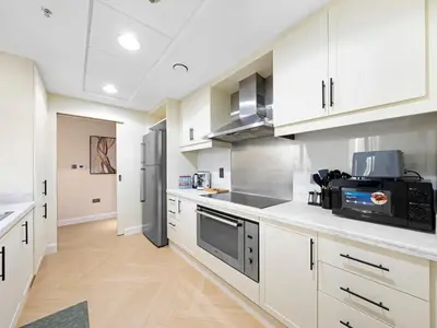 a large kitchen with white cabinets and a microwave at Burj Khalifa & Fountain Show Views 4 BHK In Downtown, 2 minutes walk to Dubai Mall in Dubai