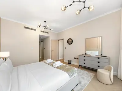a white bedroom with a bed and a dresser and a mirror at Burj Khalifa & Fountain Show Views 4 BHK In Downtown, 2 minutes walk to Dubai Mall in Dubai