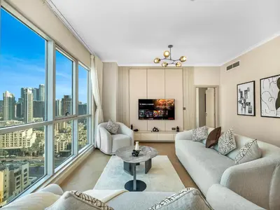 a living room with couches and a tv and large windows at Burj Khalifa & Fountain Show Views 4 BHK In Downtown, 2 minutes walk to Dubai Mall in Dubai