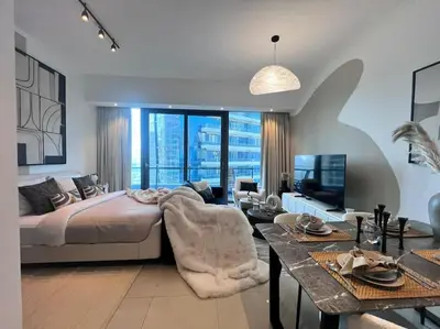 a bedroom with a large bed and a living room at The Smart Concierge - Silverene in Dubai