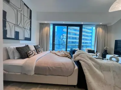 a bedroom with a large bed and a living room at The Smart Concierge - Silverene in Dubai