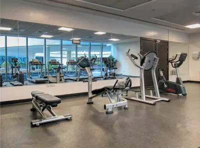 a gym with several treadmills and exercise bikes at The Smart Concierge - Silverene in Dubai