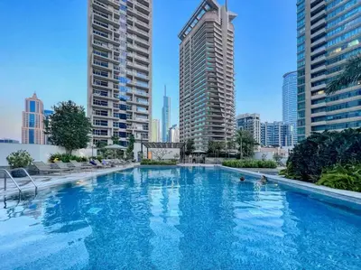 a large swimming pool in a city with tall buildings at The Smart Concierge - Silverene in Dubai