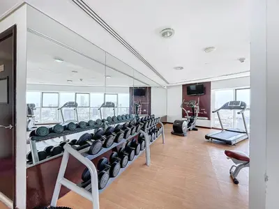 a gym with a lot of treadmills and machines at The Bridge - Tranquil Two Bedroom in Sports City in Dubai