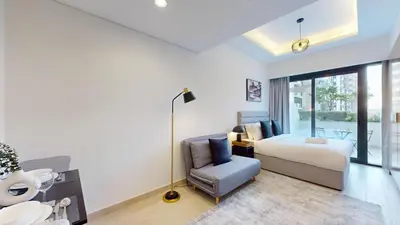 a bedroom with a bed and a chair at Azizi Riviera 9 - Bright Studio in Meydan in Dubai